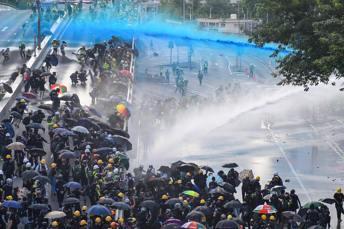 Pro-democracy protesters react as police fire water cannons outside the government headquarters in Hong Kong on Sept. 15, 2019. (Nicolas Asfouri/AFP/Getty Images)