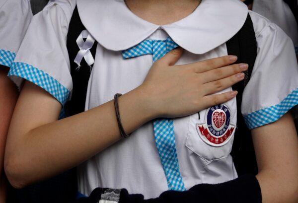 A student out her hand on the chest during a strike to condemn police shooting of a teenager in Hong Kong, Oct. 2, 2019. (AP Photo/Vincent Yu)