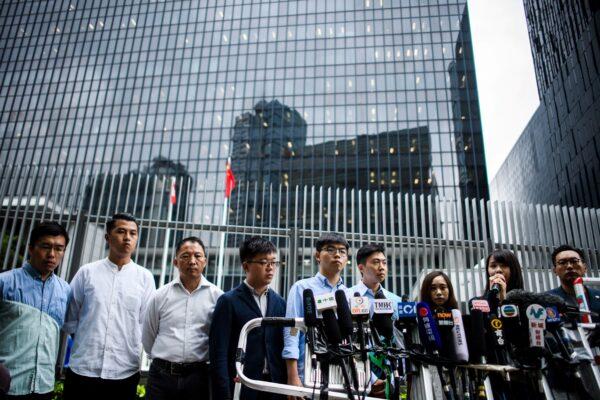 Pro-democracy activist Joshua Wong (C), Kelvin Lam (4th R) and other pro-democracy lawmakers speak to the media outside the Legislative Council (LegCo) in Hong Kong on Oct. 29, 2019. (Anthony Wallace/AFP via Getty Images)