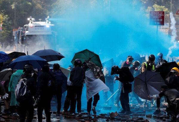Protesters are sprayed with blue liquid from water cannon during clashes with police outside Hong Kong Polytechnic University (PolyU) in Hong Kong, on Nov. 17, 2019. (Tyrone Siu/Reuters)