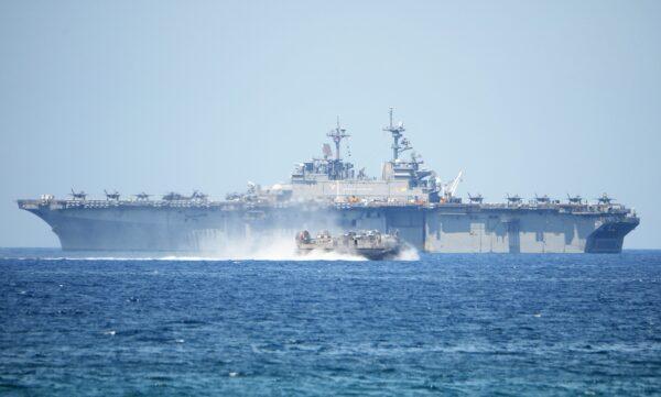 A US Navy hovercraft speeds past the USS Wasp, a US Navy multipurpose amphibious assault ship, during the amphibious landing exercises as part of the annual joint U.S.–Philippines military exercise on the shores of San Antonio town, facing the South China Sea. (Ted Aljibe/AFP via Getty Images)