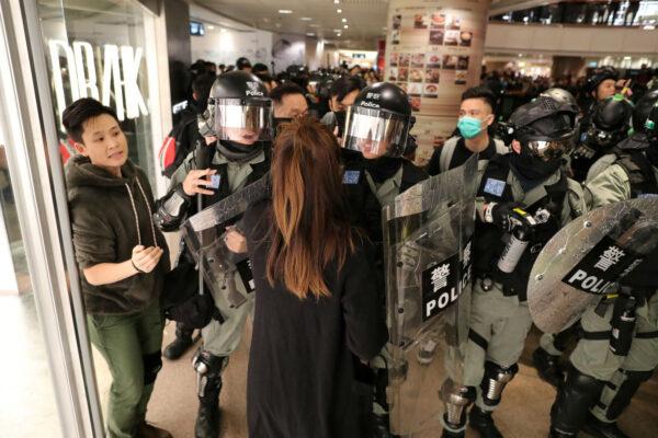 Riot police push back a shopper as Hong Kong protesters march in Harbour City shopping mall in Hong Kong, China, December 21, 2019. REUTERS/Lucy Nicholson