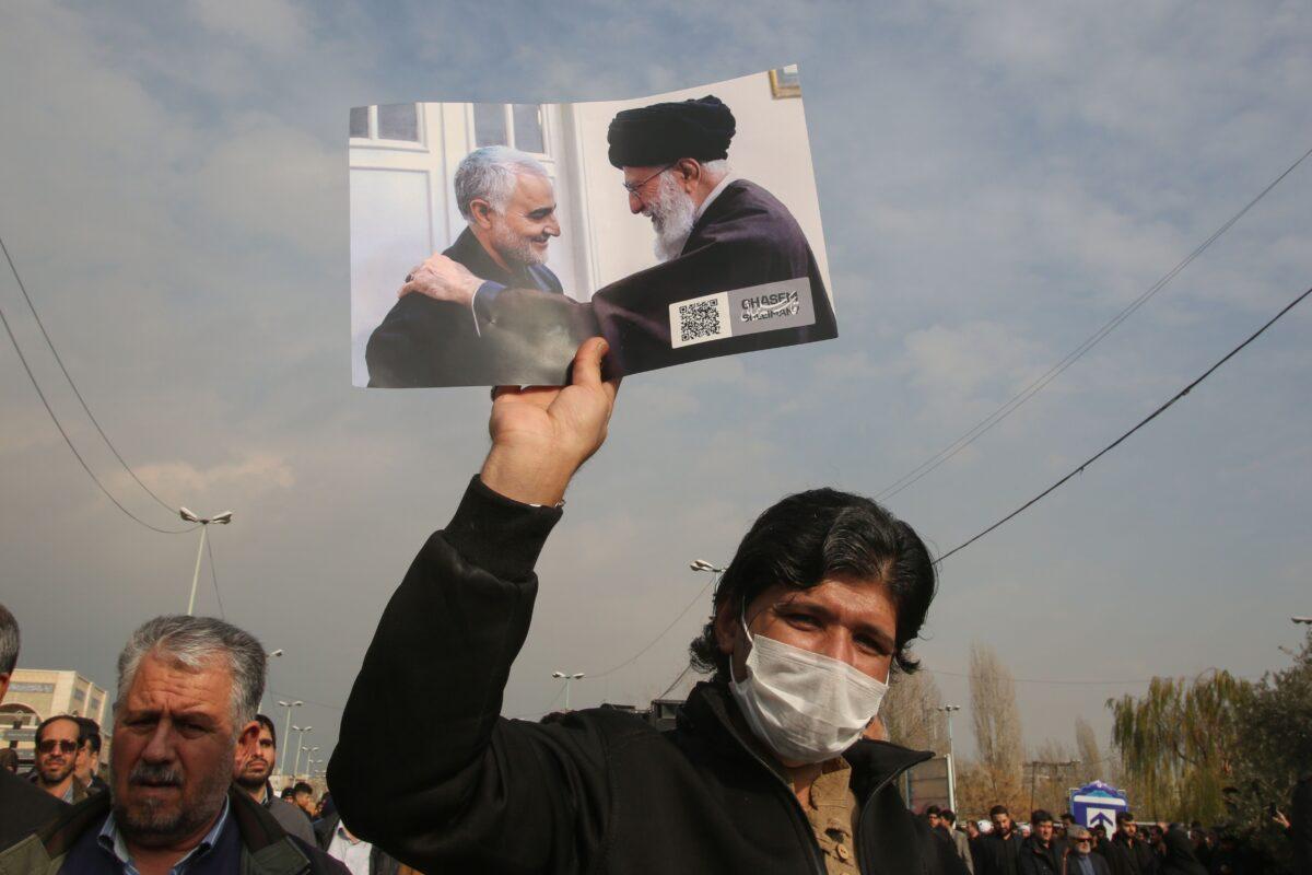 A man holds a picture of Iran's supreme leader Ayatollah Ali Khamenei with Iranian Revolutionary Guards Gen. Qassem Soleimani (L) during a demonstration in Tehran on Jan. 3, 2020. (Atta Kenare/AFP via Getty Images)