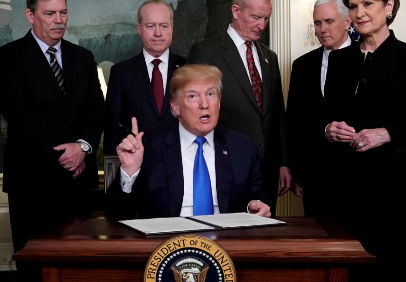U.S. President Donald Trump, surrounded by business leaders and administration officials, prepares to sign a memorandum on intellectual property tariffs on high-tech goods from China, at the White House in Washington, D.C. on March 22, 2018. (Jonathan Ernst/Reuters)