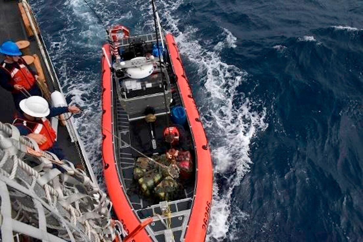 Crew members from the cutter Thetis hoist interdicted drugs seized in international waters of the Eastern Pacific Ocean, on Nov. 16, 2019. (PO1 Mark Barney/U.S. Coast Guard via AP).