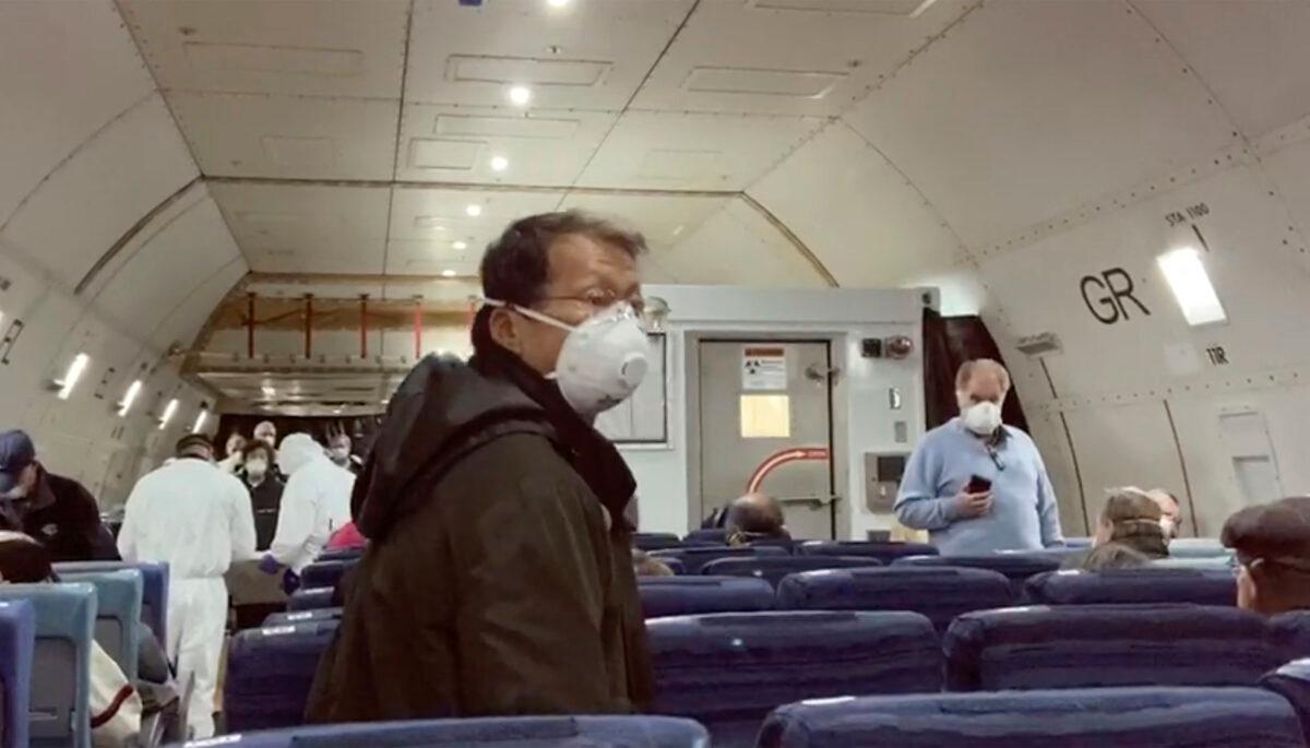 U.S. passengers who evacuated off the quarantined cruise ship the Diamond Princess, board a Kalitta Air plane bound for the U.S., at Haneda airport in Tokyo on Feb. 17, 2020. (Cheryl and Paul Molesky via AP)