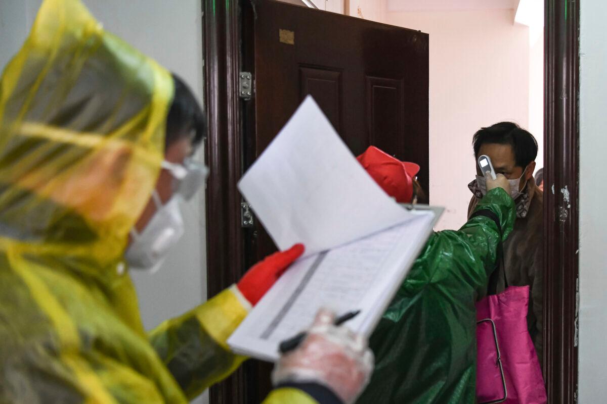 Workers go door to door to check the temperature of residents during a health screening campaign in the Qingheju Community, Qingshan District of Wuhan in central China's Hubei Province. (Cheng Min/Xinhua via AP)