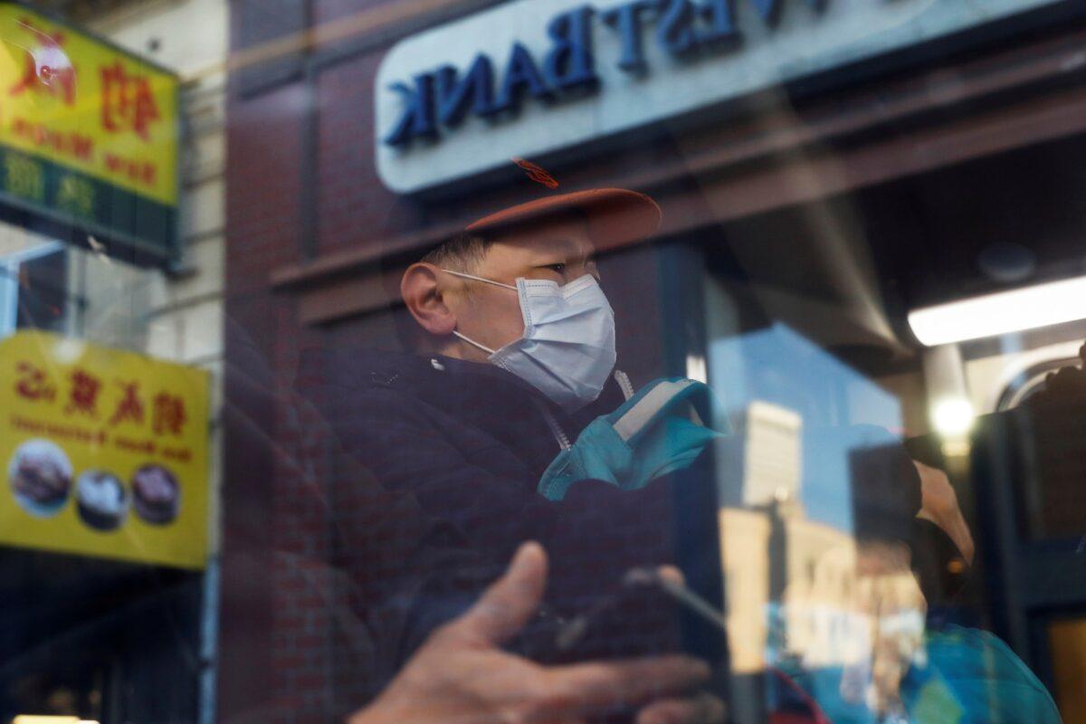 A man wears a face mask onboard a public bus in the Chinatown section of San Francisco, Calif., on Feb. 25, 2020. (Shannon Stapleton/Reuters)