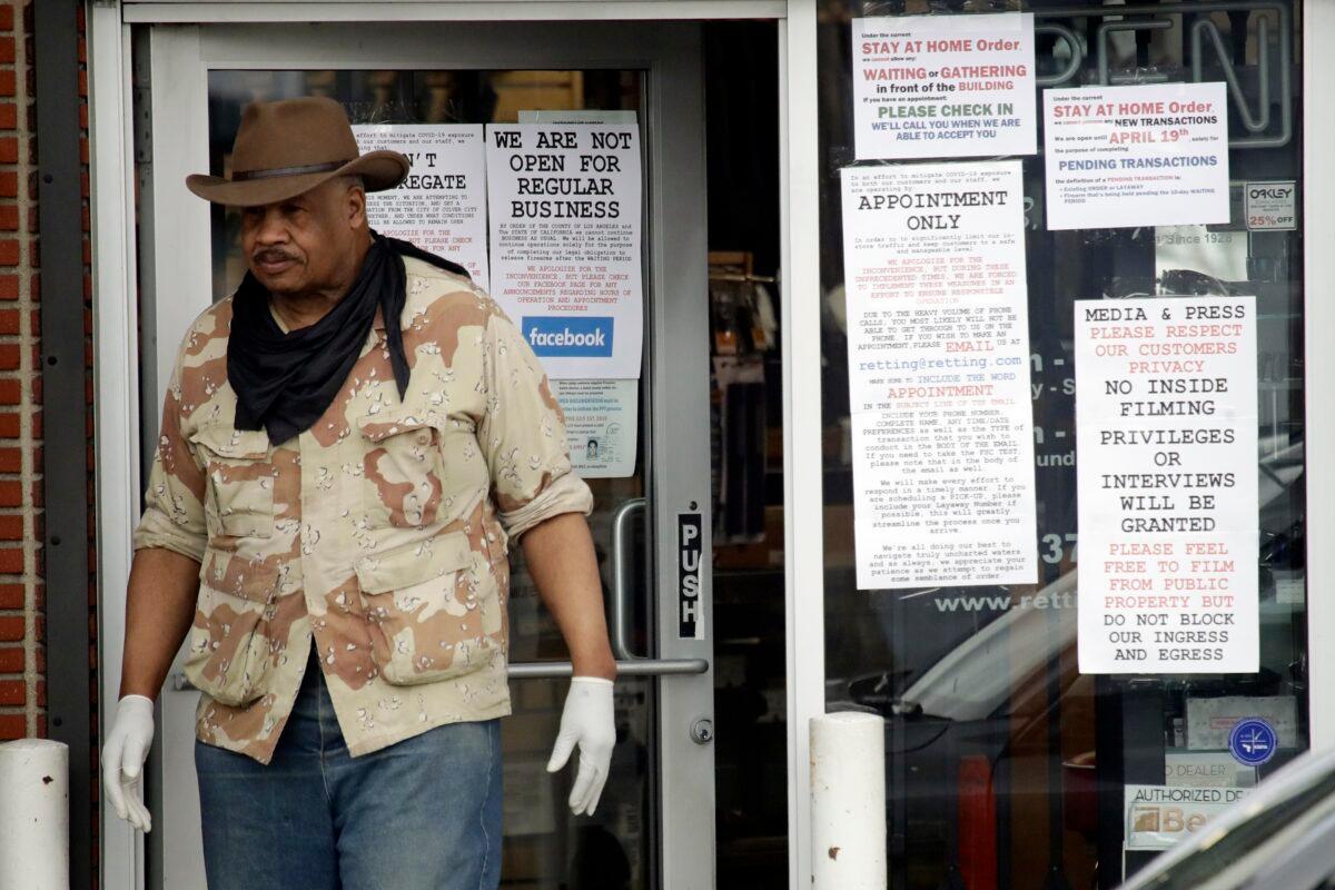An employee stands at the entrance to a guns shop in Culver City, Calif., on March 24, 2020. (Marcio Jose Sanchez/AP Photo)