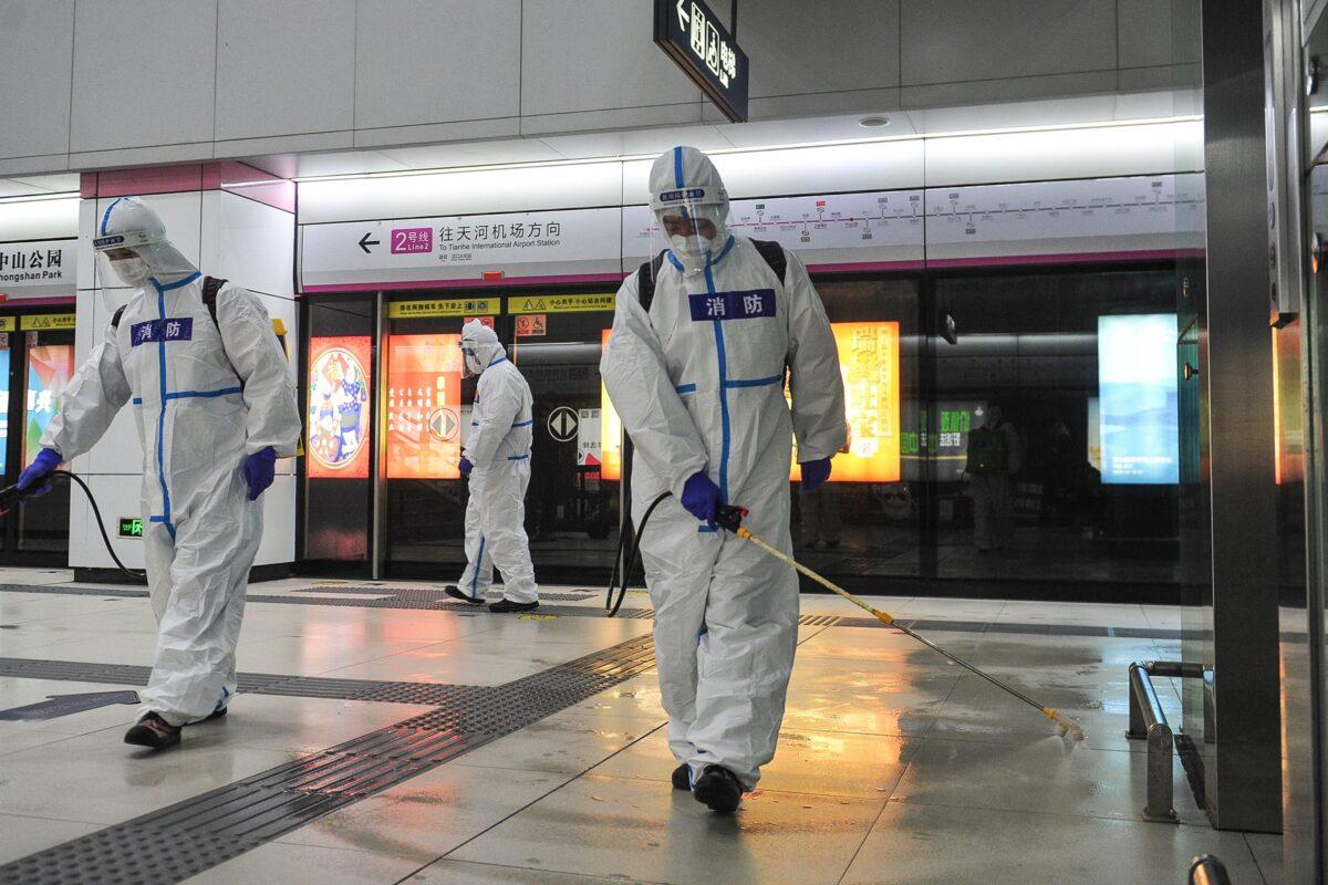 Staff members spray disinfectant at a subway station in Wuhan, in China's central Hubei Province on March 27, 2020. (STR/AFP via Getty Images)