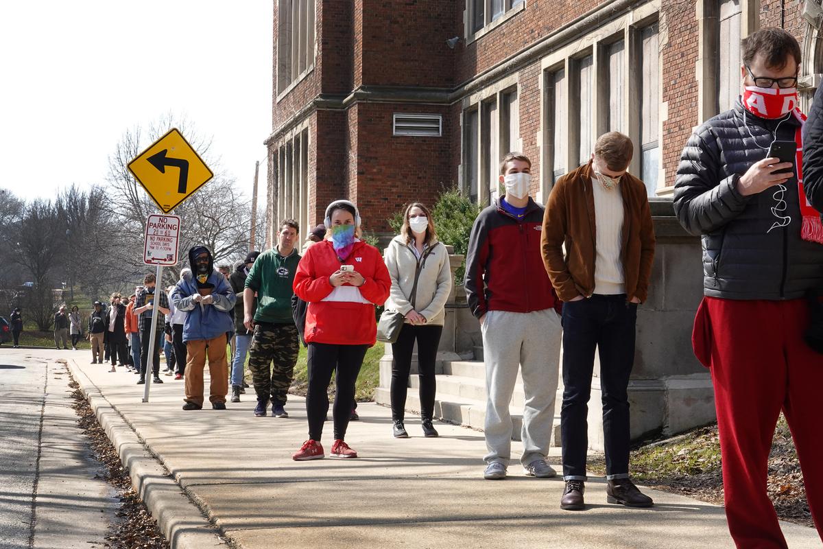 Voters wait in line to enter a polling place at Riverside University High School in Milwaukee, Wis., on April 7, 2020. (Scott Olson/Getty Images)