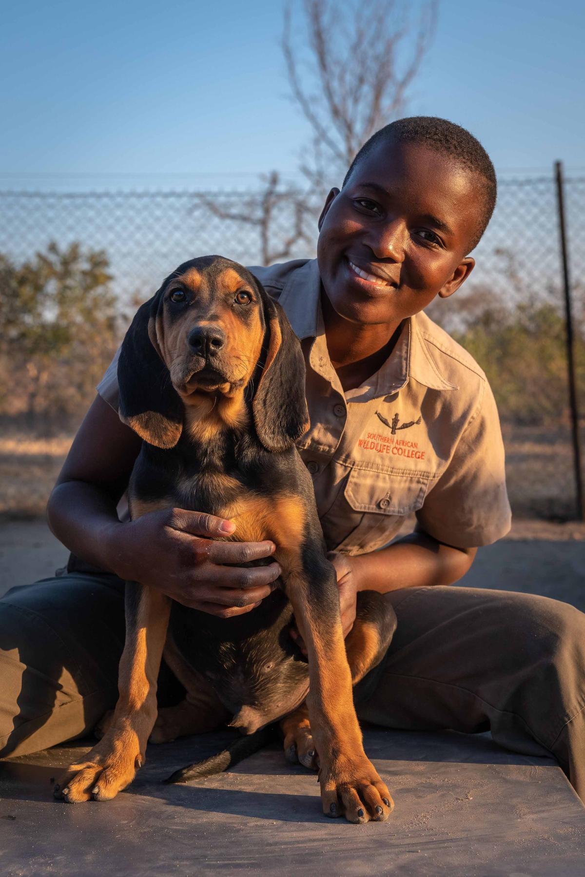 Dog handler Precious Malapane with a puppy in training to be an anti-poaching dog (Caters News)