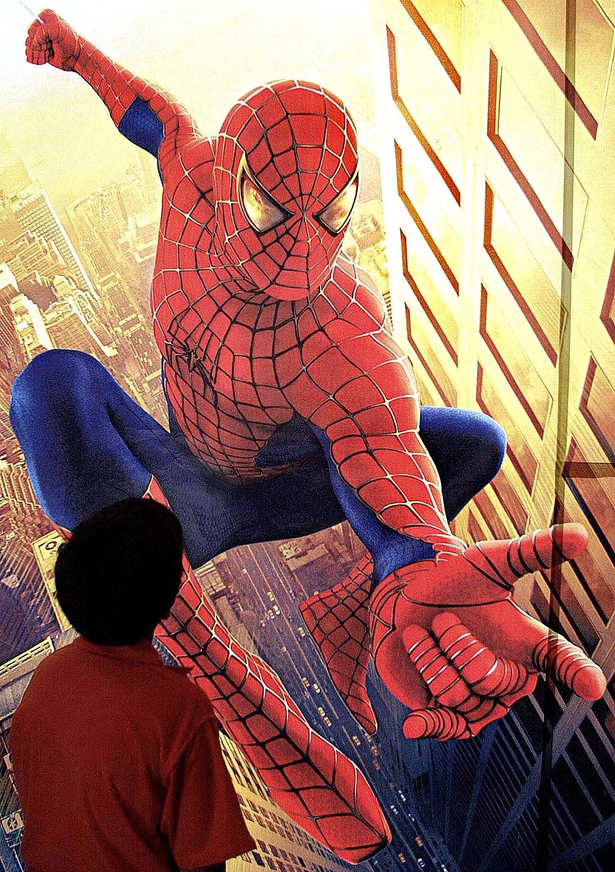 A boy looks at a poster of the movie "Spiderman" at a theatre in Bombay, May 24, 2002. (AFP/AFP via Getty Images)