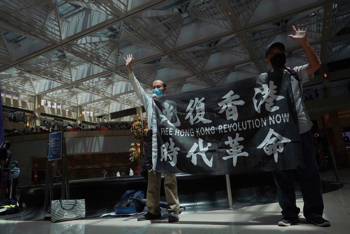Protesters gesture with five fingers, signifying the "Five demands - not one less" in a shopping mall during a protest against China's national security legislation for the city, in Hong Kong on June 1, 2020. (Vincent Yu/AP Photo)