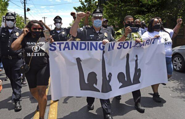 Camden County Metro Police Chief Joe Wysocki raises a fist while marching with Camden residents and activists in Camden, N.J., on May 30, 2020. (April Saul via AP)