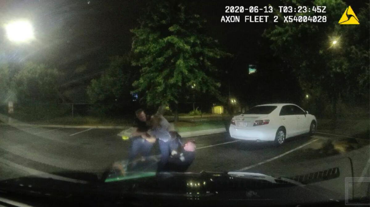 This screen grab taken from dashboard camera video provided by the Atlanta Police Department shows Rayshard Brooks, center, struggling with Officers Garrett Rolfe, left, and Devin Brosnan in the parking lot of a Wendy's restaurant, in Atlanta, Ga., on June 13, 2020. (Atlanta Police Department via AP)