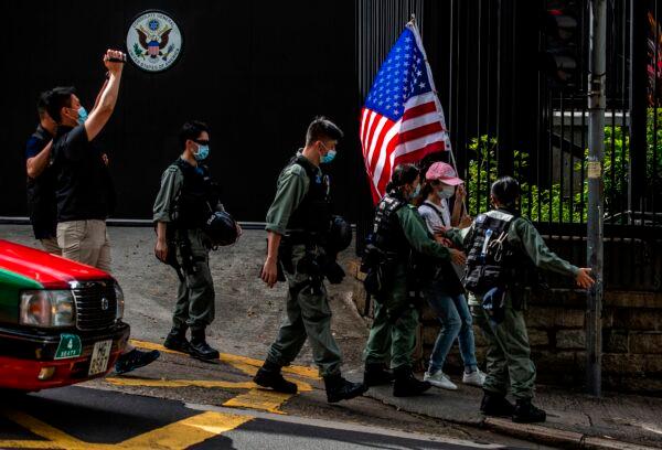 Police remove a woman holding a U.S. flag from outside the U.S. consulate during a march to celebrate July Fourth in Hong Kong on July 4, 2020. (Isaac Lawrence/AFP via Getty Images)