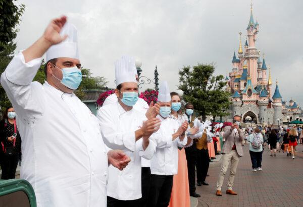 Chefs welcome the first visitors arriving at Disneyland Paris as the theme park reopens its doors to the public in Marne-la-Vallee, near Paris, following the coronavirus disease (COVID-19) outbreak in France, on July 15, 2020. (Charles Platiau/Reuters)