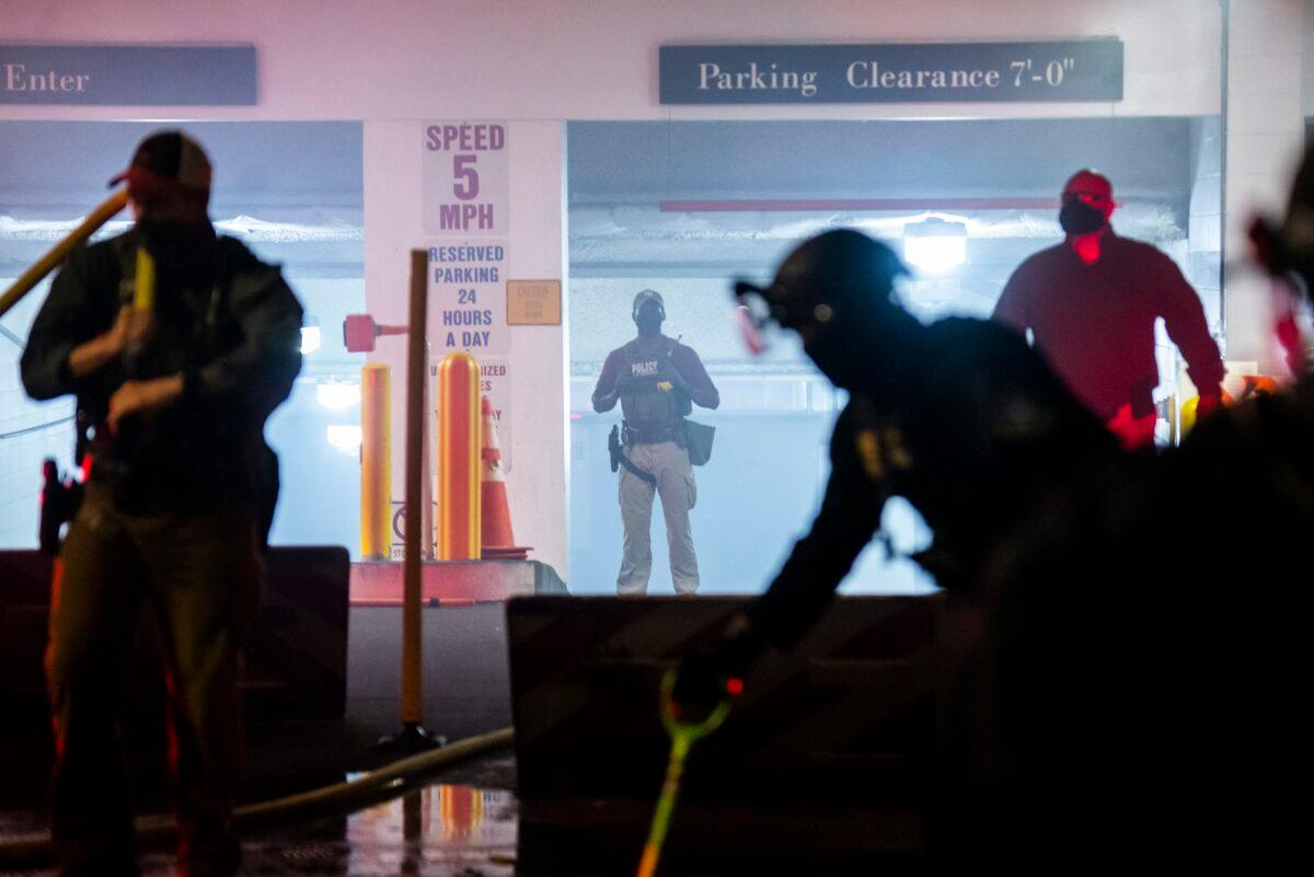 Federal officers work to put out a fire that protesters started near the rear entrance to the Mark O. Hatfield U.S. Courthouse in Portland, Ore., early on Aug. 2, 2020. (Nathan Howard/Getty Images)