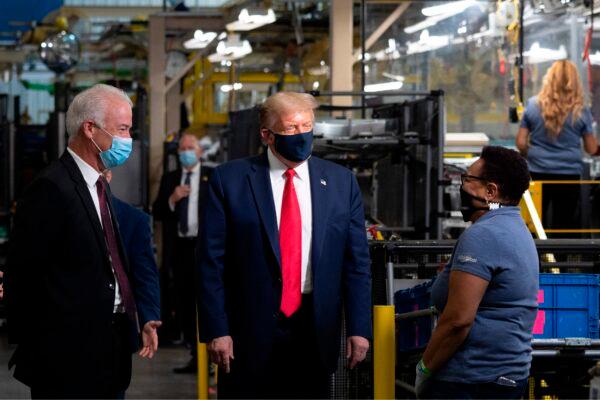 U.S. President Donald Trump (2nd L) wears a facemask as he speaks to an employee while touring the Whirlpool Corporation Manufacturing Plant in Clyde, Ohio, on Aug. 6, 2020. (Jim Watson/AFP via Getty Images)