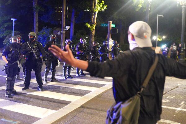 A protester taunts police as they disperse a crowd of about 150 people from around Portland City Hall, in Portland, Ore., on Aug. 25, 2020. Protests and riots have been a nightly occurrence in the city since May. (Nathan Howard/Getty Images)