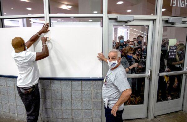 Poll workers board up windows of the ballot counting area at the TCF Center in Detroit on Nov. 4, 2020. (Seth Herald/AFP via Getty Images)