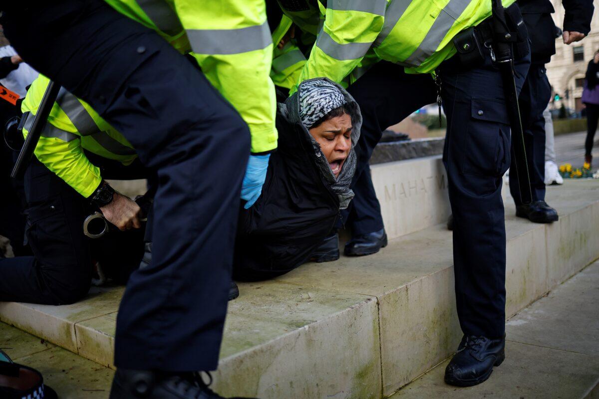 Police officers detain a protestor during an anti-CCP virus lockdown demonstration outside the Houses of Parliament in Westminster, central London on Jan. 6, 2021. (Tolga Akmen/AFP via Getty Images)