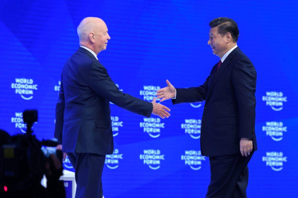 China's President Xi Jinping (R) shakes hands to Founder and Executive Chairperson of the World Economic Forum, Klaus Schwab (L) prior to delivering a speech during the first day of the World Economic Forum in Davos, Switzerland, on Jan. 17, 2017. (Fabrice Coffrini /AFP via Getty Images)