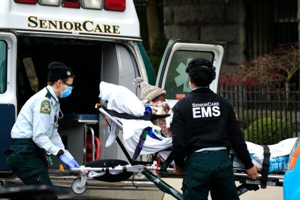 Emergency medical workers are seen unloading a patient outside a nursing home in Brooklyn, New York, on April 18, 2020. (Justin Heiman/Getty Images)