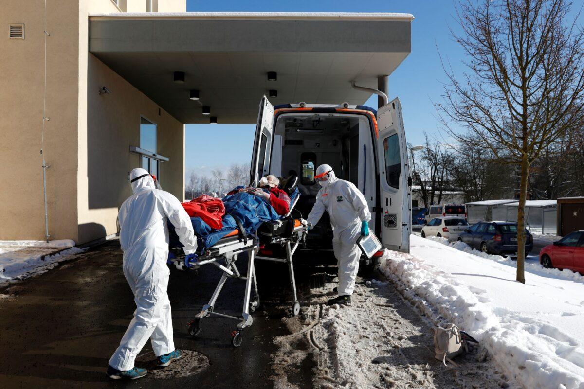 Medical workers move a COVID-19 patient into an ambulance at a hospital overrun by the pandemic in Cheb, Czech Republic on Feb. 12, 2021. (Petr David Josek/AP Photo/File)