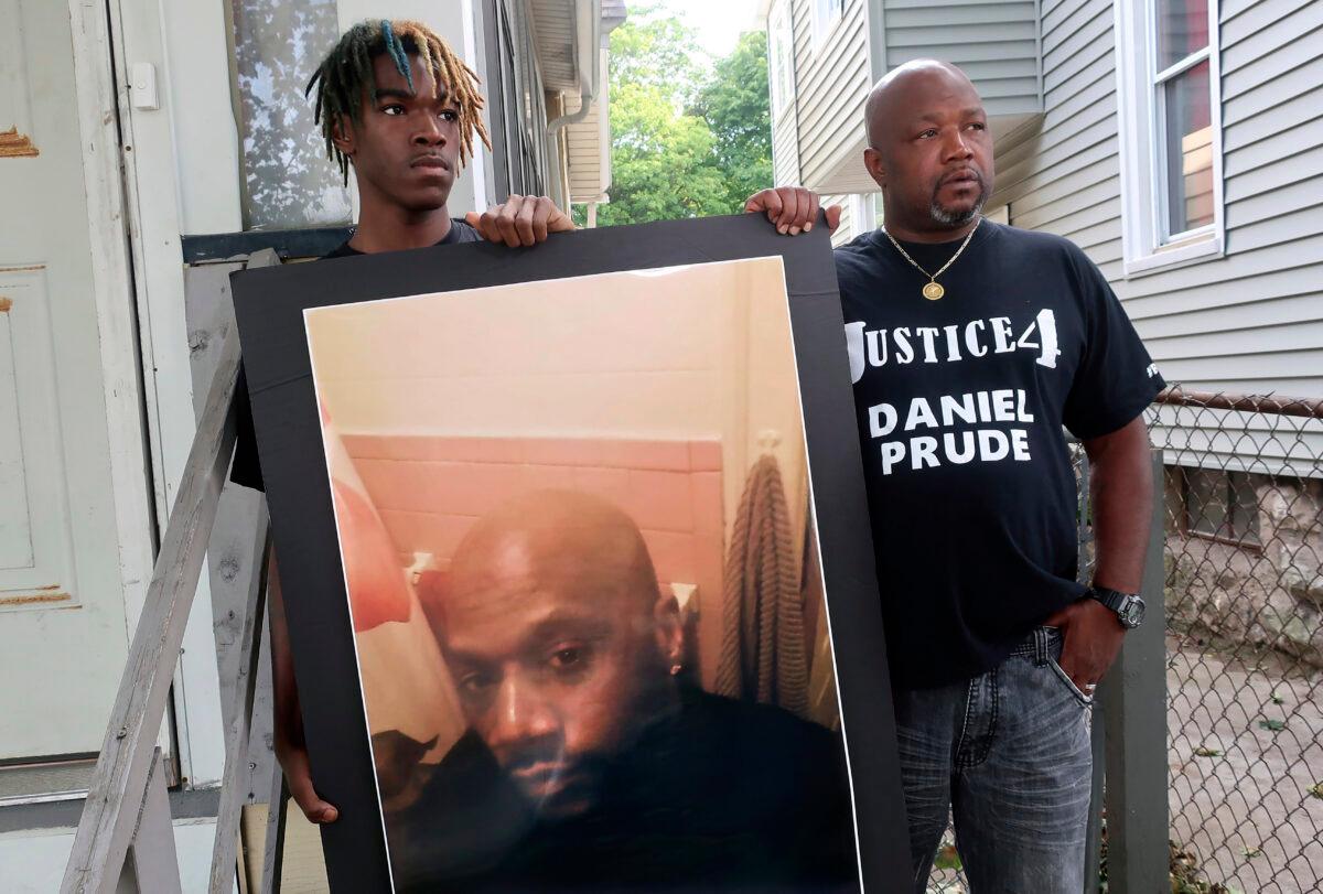 Joe Prude (R), brother of Daniel Prude, and Daniel's nephew Armin, stand with a picture of Daniel Prude in Rochester, N.Y., on Sept. 23, 2020. (Ted Shaffrey, File/AP Photo)