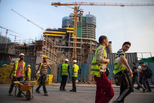 Chinese construction workers head home after work at a new shopping mall called The Mall at One Galle Face, which is part of the Chinese-managed Shangri-La retail and office complex in Colombo, Sri Lanka, on Nov. 10, 2018. (Paula Bronstein/Getty Images)
