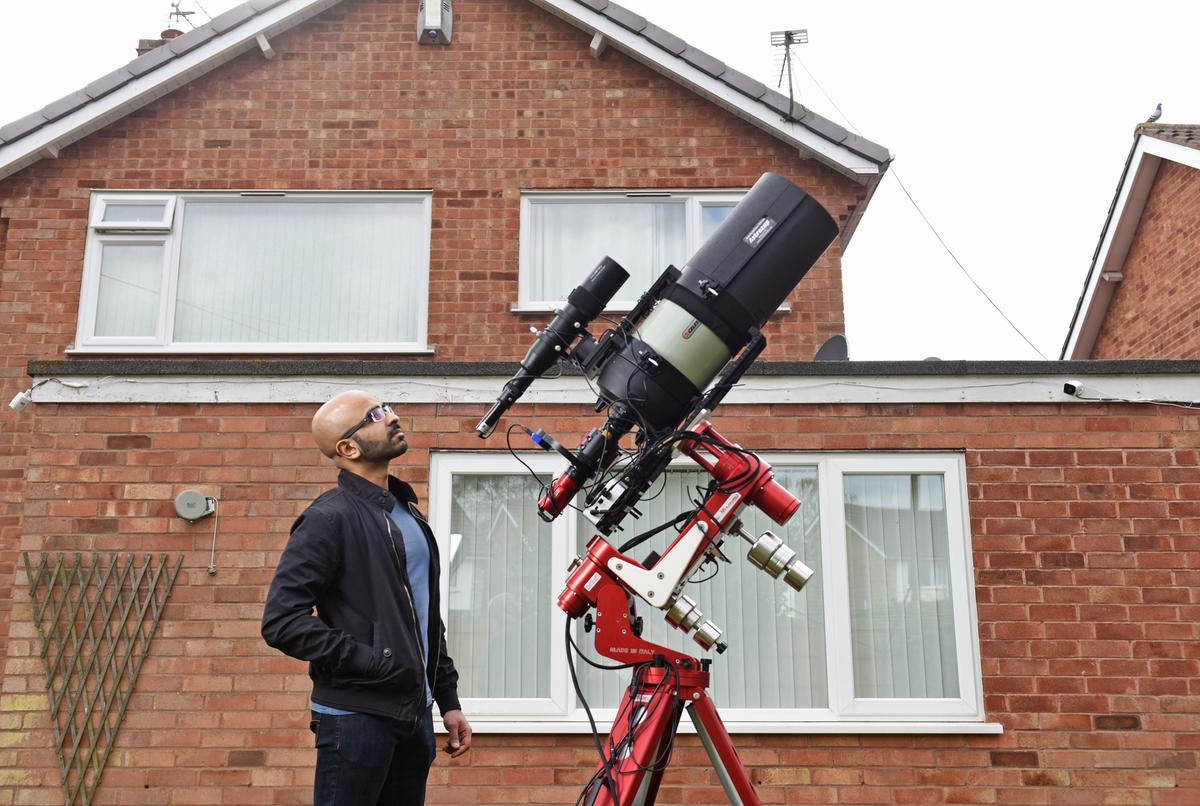 Syed Taha in his garden in Leicestershire, UK, with his telescope where he takes pictures which are out of this world. (Caters News)