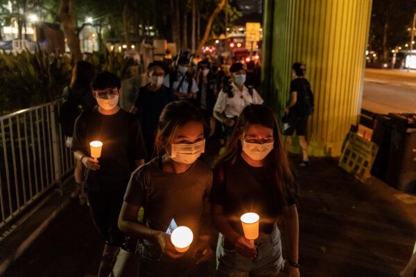 People hold candles as they walk near Victoria Park after police closed the venue where Hong Kong people traditionally gather annually to mourn the victims of China's Tiananmen Square crackdown in 1989, in the Causeway Bay district in Hong Kong on June 4, 2021. (Anthony Kwan/Getty Images)