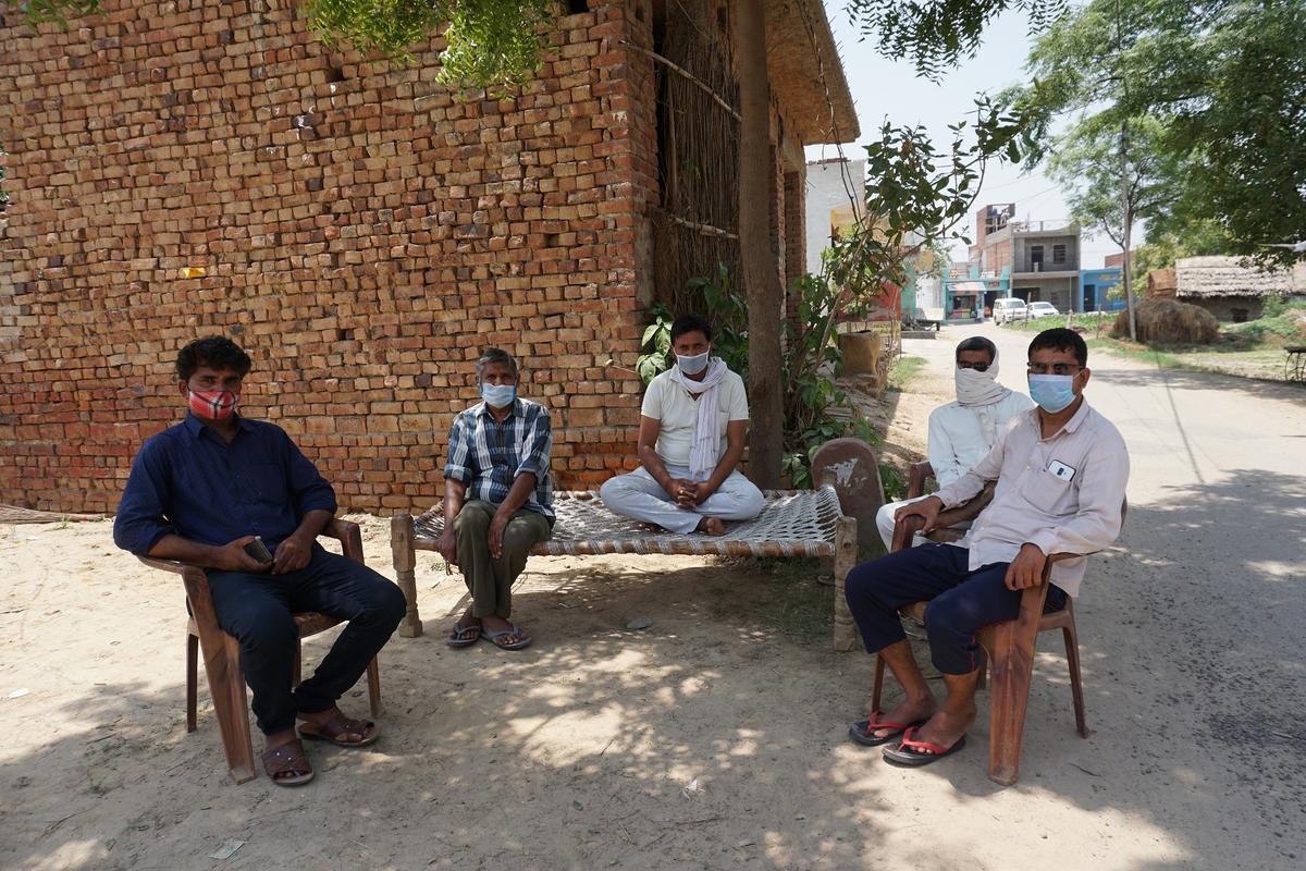 Om Prakash (L), the village council head of Kahira, with other villagers by the side of a street on May 27, 2021. (Venus Upadhayaya/Epoch Times)
