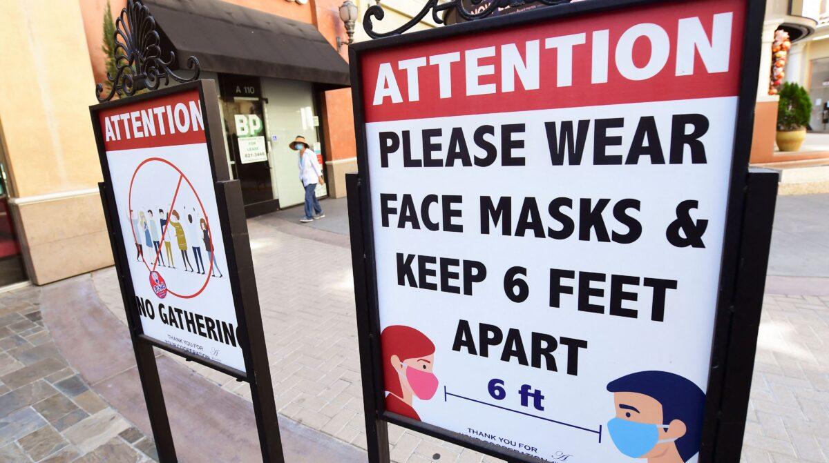 Signs reminding people of social distancing and wearing face masks remain at a mall in California on June 14, 2021. (Frederic J. Brown/AFP via Getty Images)