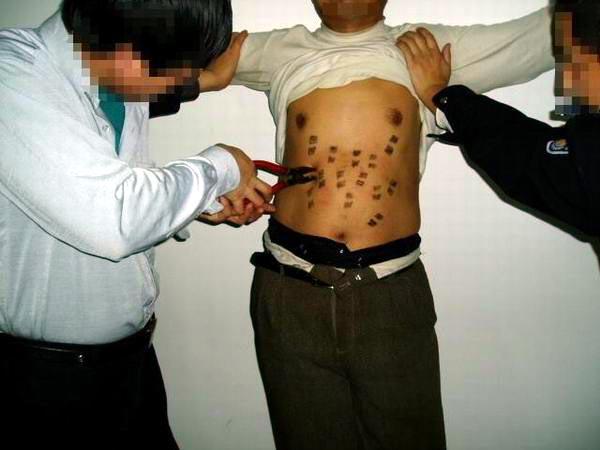 Reenactment of pinching the body with pliers. (<a href="https://en.minghui.org/">Minghui.org</a>)