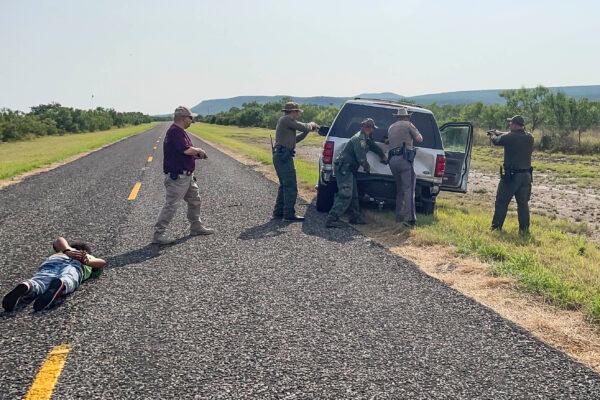 Texas, Nebraska, and Iowa State Troopers, along with Border Patrol and the Kinney County Constable, detain the driver and prepare to search a stolen vehicle in Kinney County, Texas, on July 21, 2021. (Charlotte Cuthbertson/The Epoch Times)
