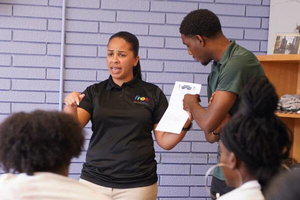 Ana Sierra, career development specialist at Free Lunch Academy, reminds students to bring weekly timesheets back on time, uncrumpled. (Cara Ding/The Epoch Times)