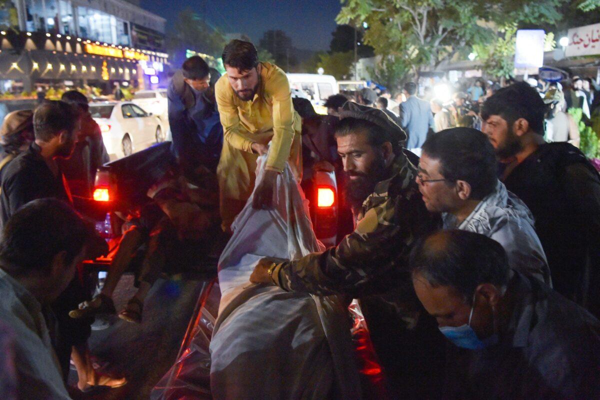 Volunteers and medical staff unload bodies from a pickup truck outside a hospital in Kabul, Afghanistan, on Aug. 26, 2021. (Wakil Kohsar/AFP via Getty Images)