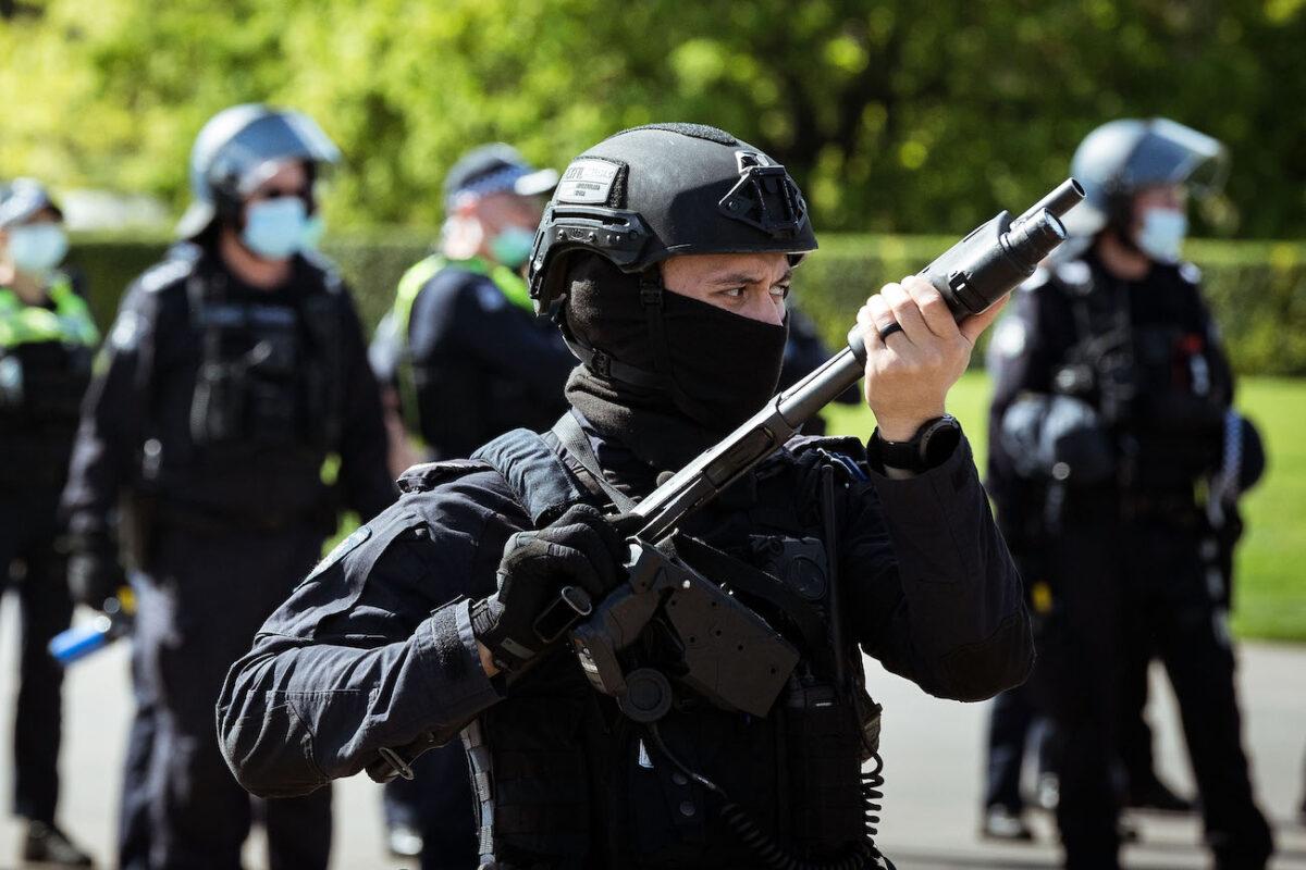 A riot police officer wields a weapon looking at protesters near the Shrine of Remembrance, in Melbourne, Australia, on Sept. 22, 2021. (Darrian Traynor/Getty Images)