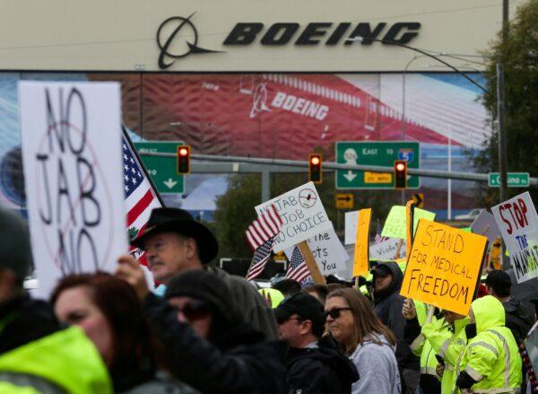 Boeing employees and others line the street to wave signs and American flags to protest the company's coronavirus disease (COVID-19) vaccine mandate, outside the Boeing facility in Everett, Washi., on Oct. 15, 2021. (Lindsey Wasson/Reuters)