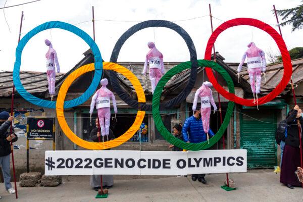 FILE - Exiled Tibetans use the Olympic Rings as a prop as they hold a street protest against the holding of the 2022 Winter Olympics in Beijing in Dharmsala, India, on Feb. 3, 2021. (AP Photo/Ashwini Bhatia, File)