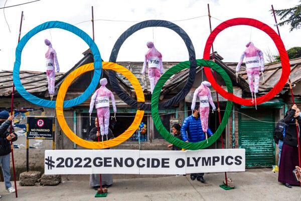 Exiled Tibetans use the Olympic Rings as a prop as they hold a street protest against the holding of the 2022 Winter Olympics in Beijing, in Dharmsala, India, on Feb. 3, 2021. (Ashwini Bhatia/AP Photo)