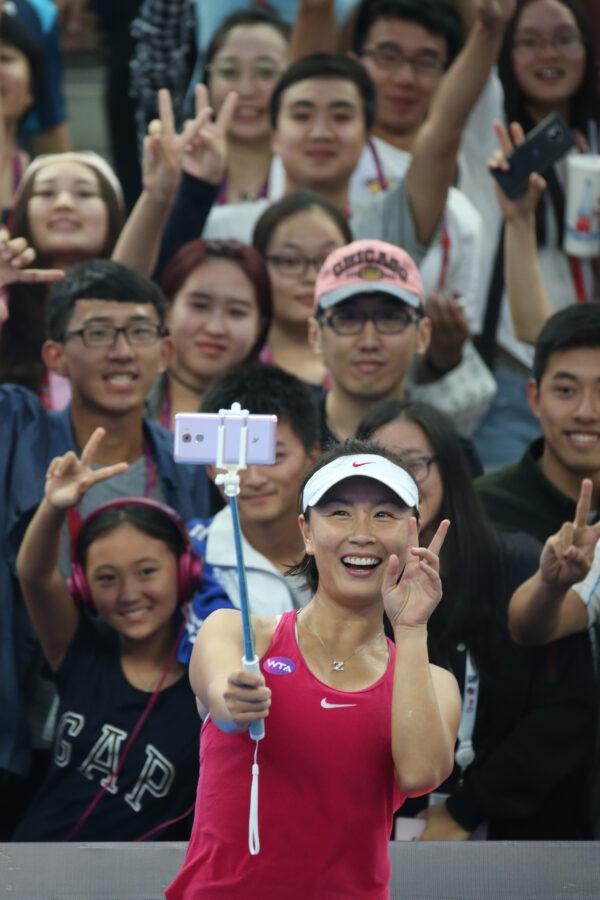 Peng Shuai of China takes a selfie with fans after winning the Women's singles first round match against Venus Williams of the USA on day three of the 2016 China Open at the China National Tennis Centre in Beijing, China, on Oct. 3, 2016. (Emmanuel Wong/Getty Images)