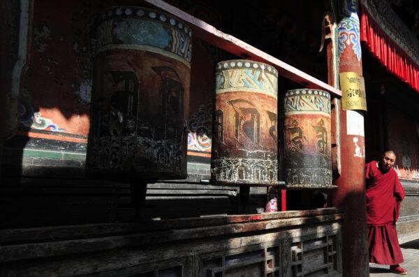 A Tibetan Buddhist monk steps out of a prayer hall where prayer wheels are hung at the Kumbum Monastery outside of Xining, in northwestern China’s Qinghai Province, on March 8, 2009. (Frederic J. Brown/AFP via Getty Images)