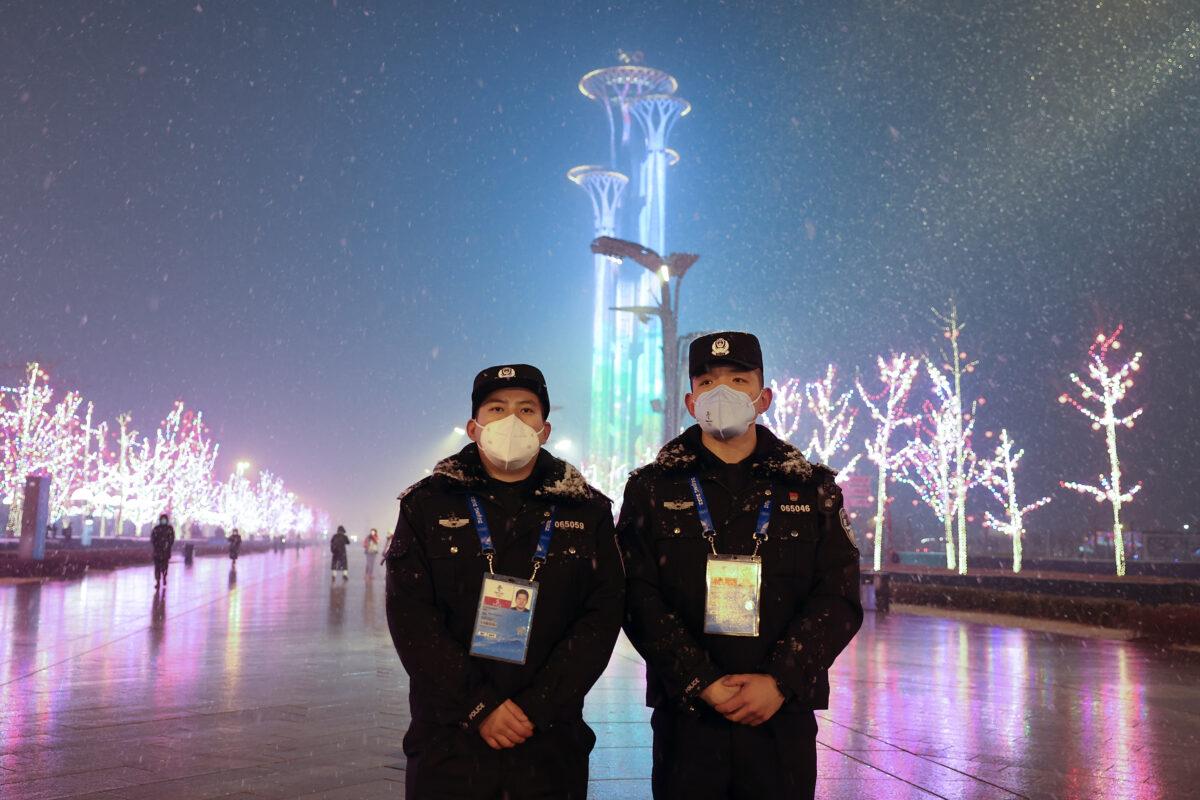 Two Chinese police officers wear protective masks as they stand in front of the Olympic Tower ahead of the Beijing Winter Olympic Games on Jan. 30, 2022. (Lintao Zhang/Getty Images)