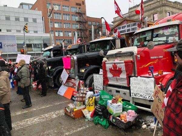 Food and necessities donated to truckers are left beside trucks parked in front of Parliament Hill in Ottawa, Canada, on Feb. 6, 2022. (Noé Chartier/The Epoch Times)