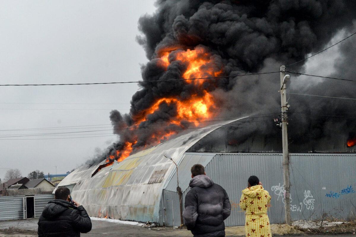 Local residents react in front of a burning building after shelling said to be by Russian forces in Ukraine's second-biggest city of Kharkiv on March 3, 2022. (Sergey Bobok/AFP via Getty Images)
