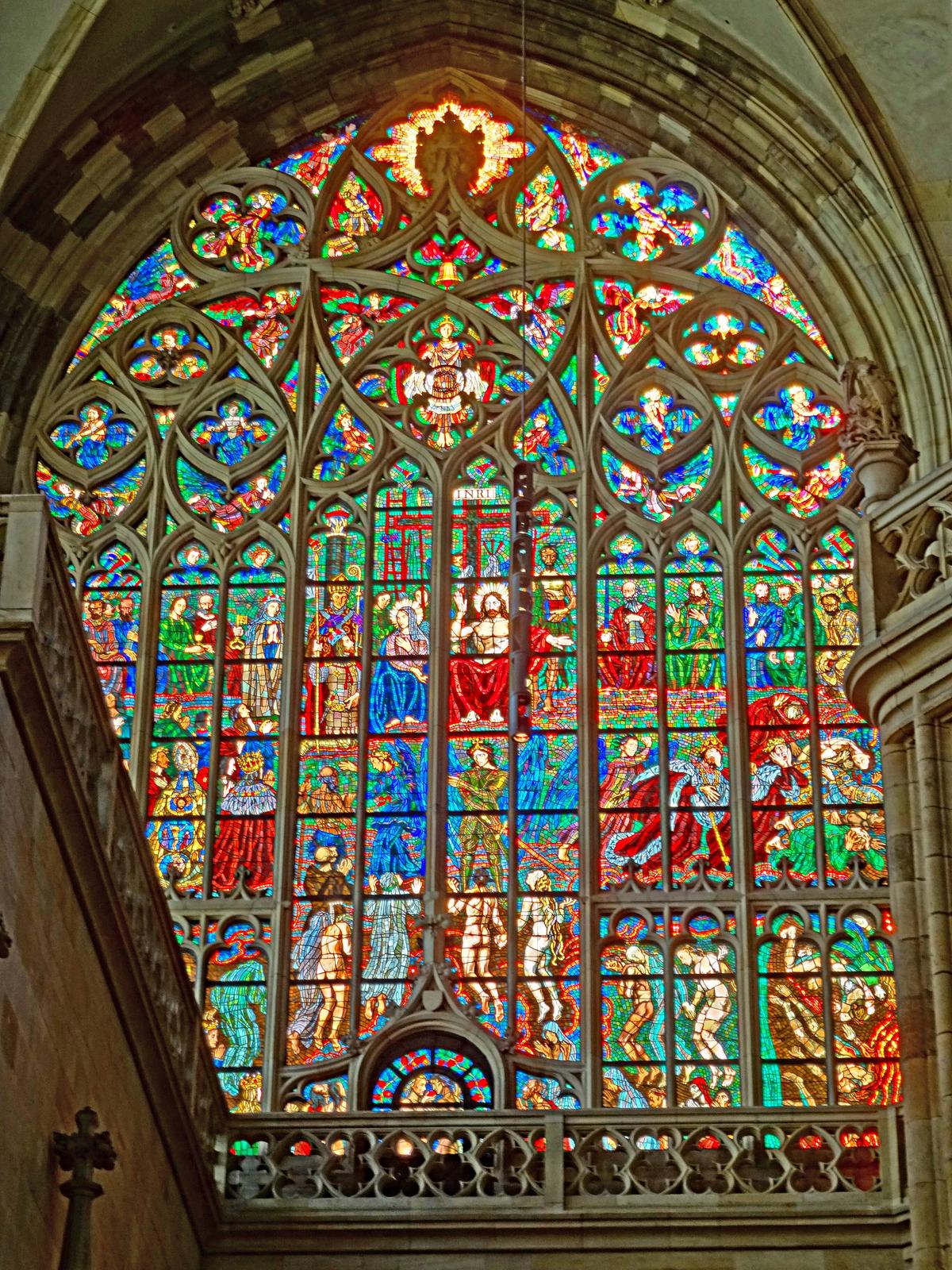 Tracery are stone structures that hold the sections of stained glass windows. Their vine-like sculptural forms create a weightless effect, lightening the atmosphere of the window composition. The scene here is a depiction by famous Prague artist Max Svabinsky of the Last Judgment. (ErwinMeier/CC BY-SA 4.0)